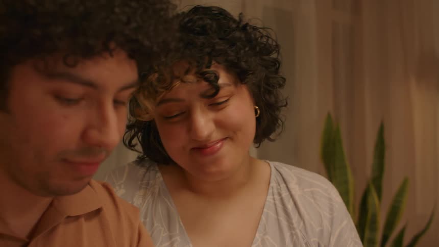 Young happy couple talking to others in a room