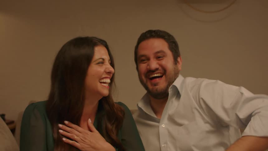 Happy couple have a lively conversation with friends at home