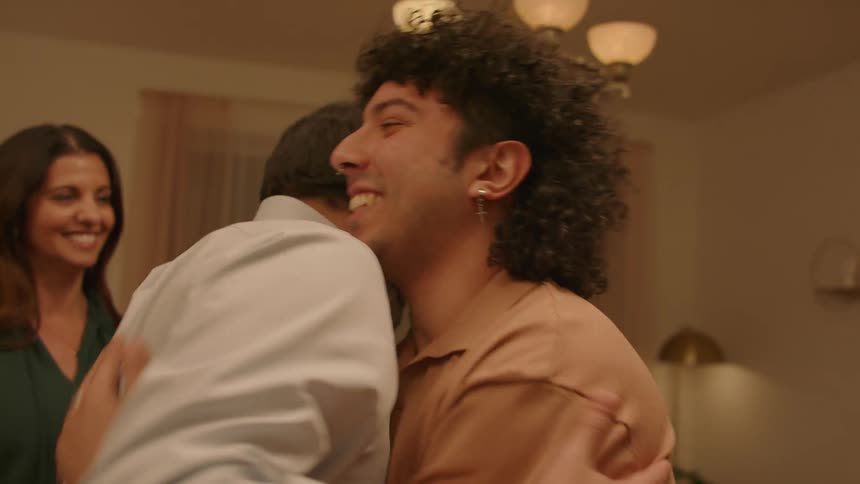 Parents hugging their son in his apartment and meeting his partner