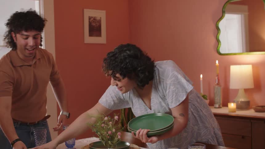 Couple at the dining table placing dishes