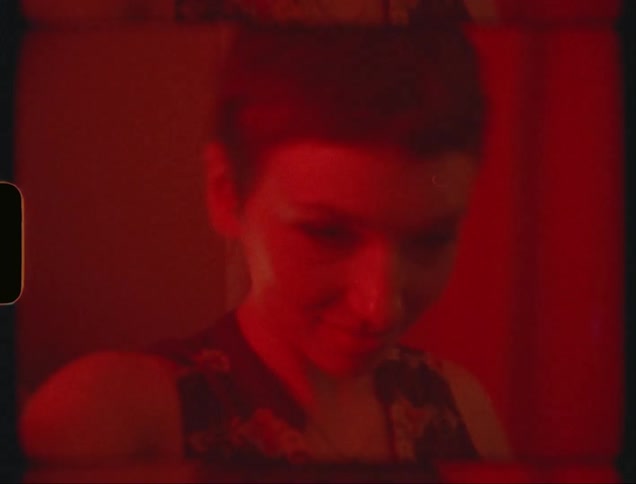 A woman with short hair happily dances next to a jukebox