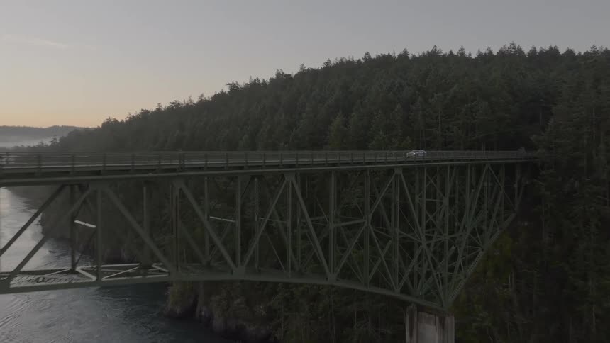Sedan vehicle crossing a bridge over the sea in a morning