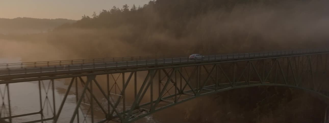 An aerial view of a car driving over an island bridge