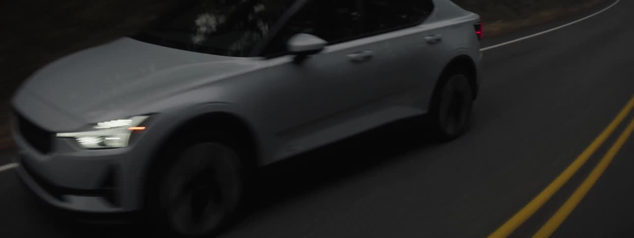 A silver car driving on a road