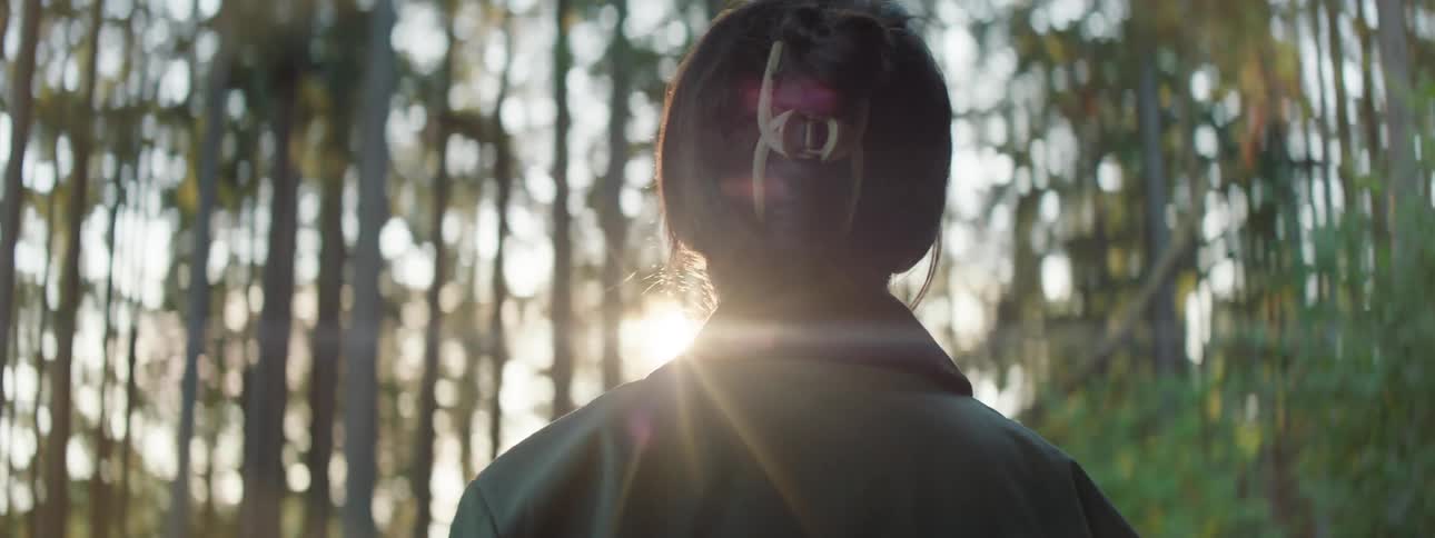 A woman admiring the sunlight in a forest