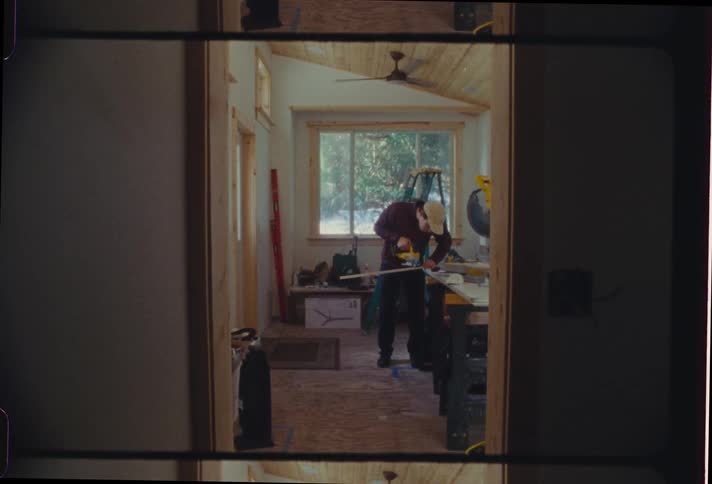 Carpenter man with a chainsaw sawing wood