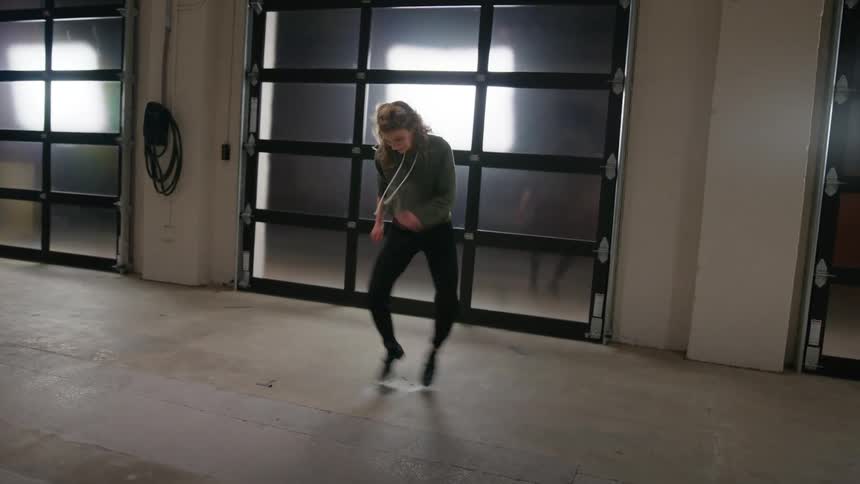 A woman tap dancing in an empty room