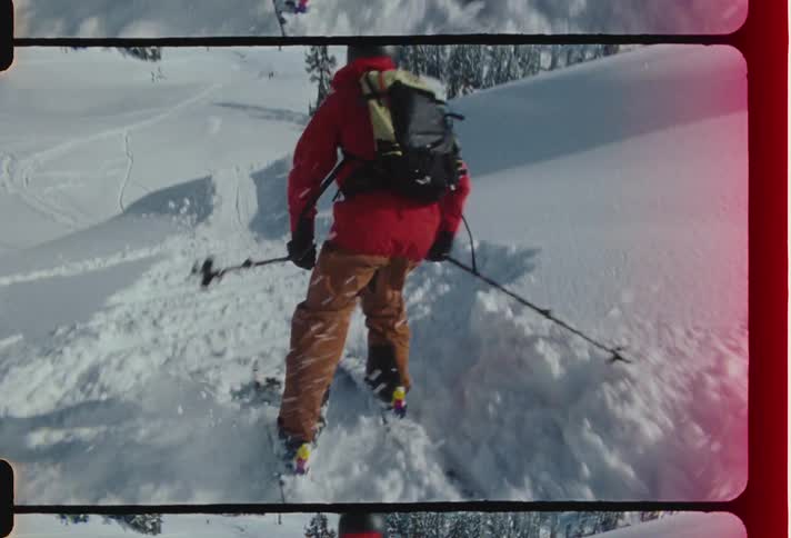 A person skiing on a snowy mountain during the day