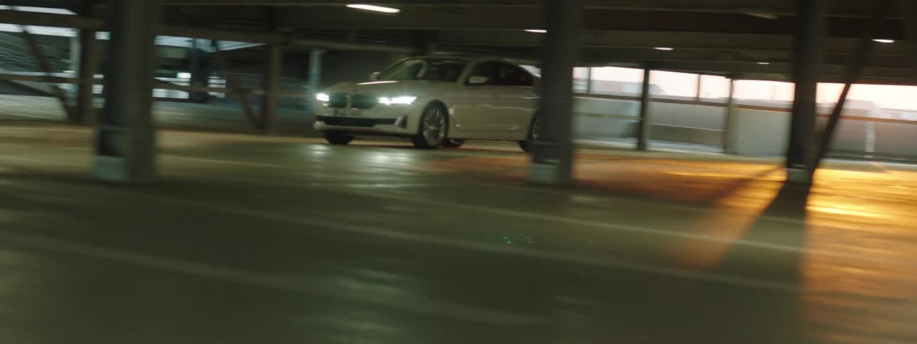 A man drives a car in the parking lot of a building