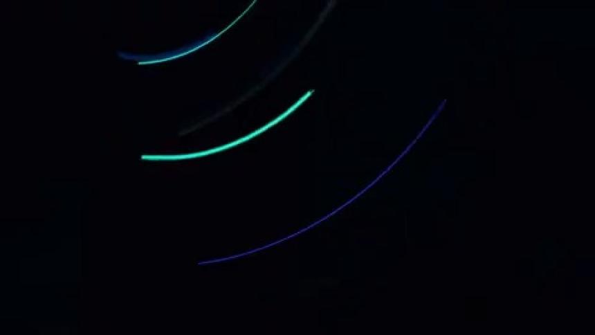 A few small lights spin very quickly in a pitch black environment