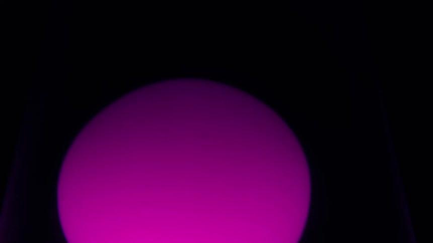 A pink sphere glowing in the dark