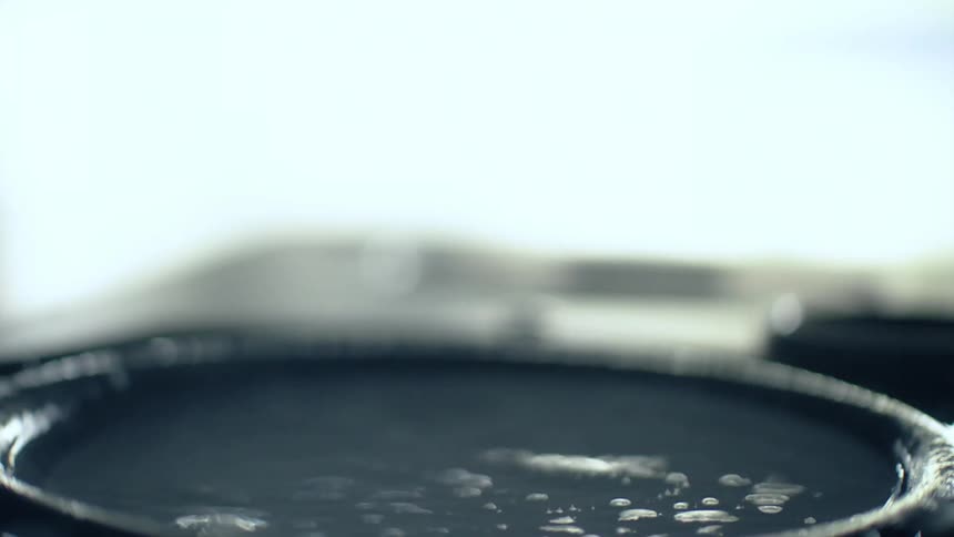 Close up of a thick dark liquid rippling with vibrations