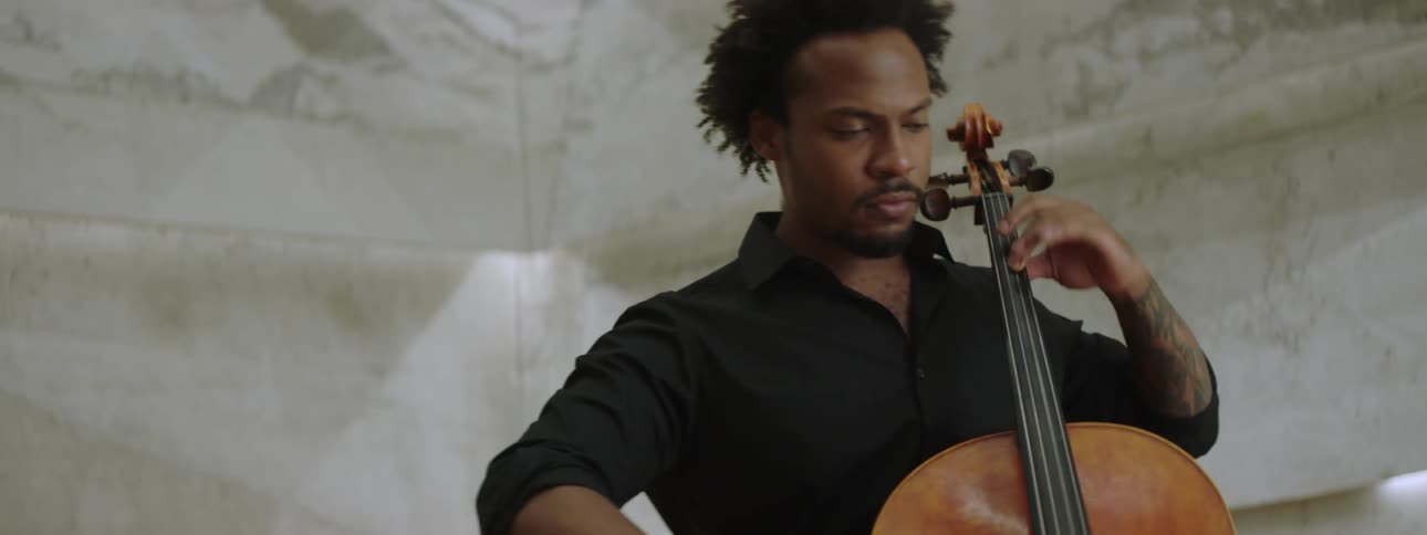 An inspired musician playing cello in front of a microphone