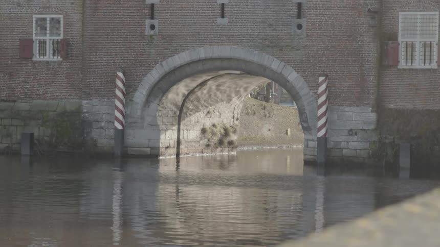 A tunnel in a canal in a neighborhood on a sunny day