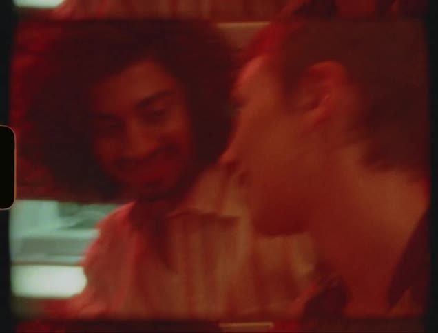 Two people drinking alcohol together at a bar at night