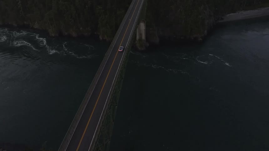 Aerial of a car moving on the bridge at dawn