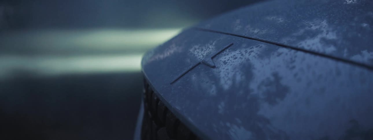 EV Polestar logo on car driving through rainy weather