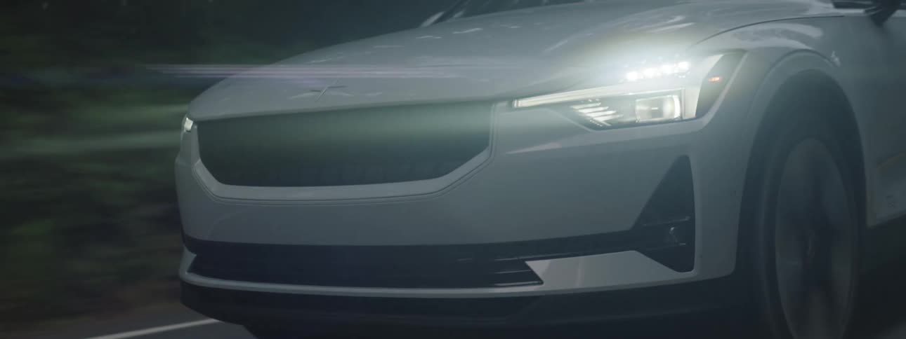 White tesla sedan traveling down a road