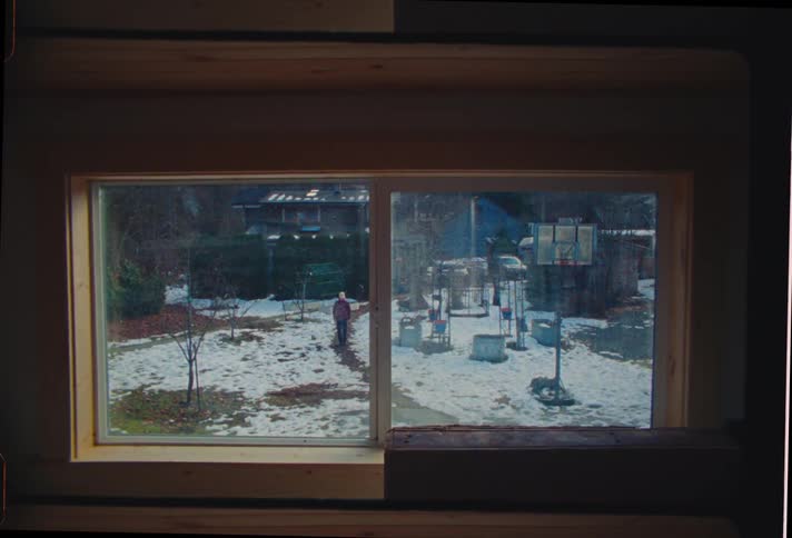 Window overlooking a public square with a person walking in the snow