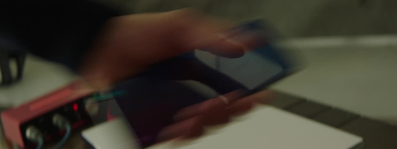 Man in suit closed his laptop and removed his phone from the charging cable