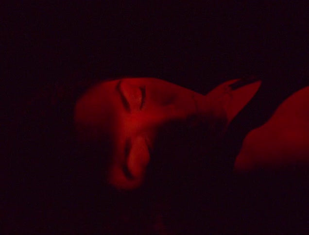 A woman blinks and slowly opens her eyes while laying on her back