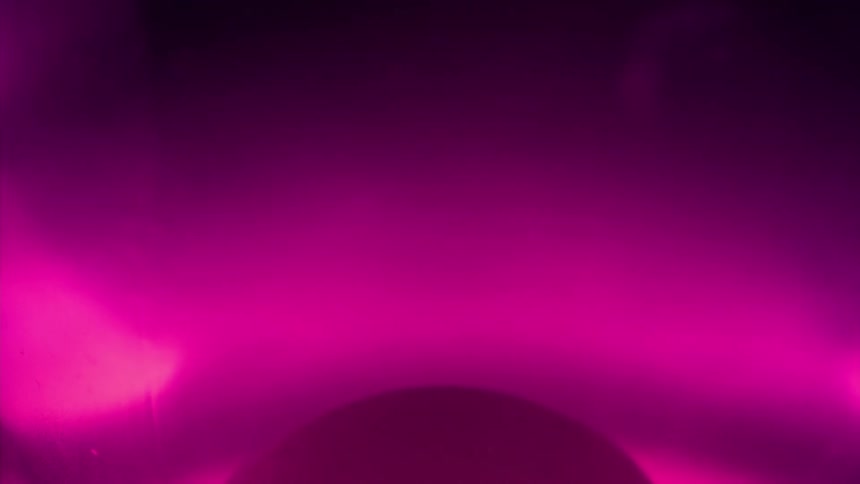 A pink fluid forms droplets that rise up and then float back down