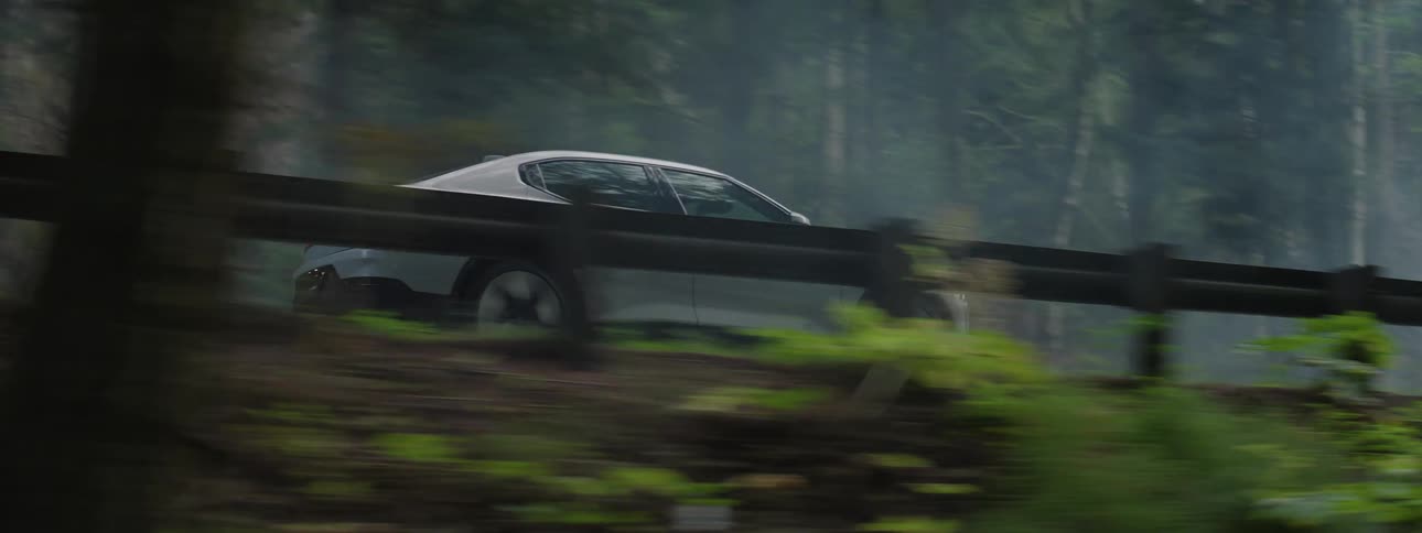 White sedan car driving on a road in the forest