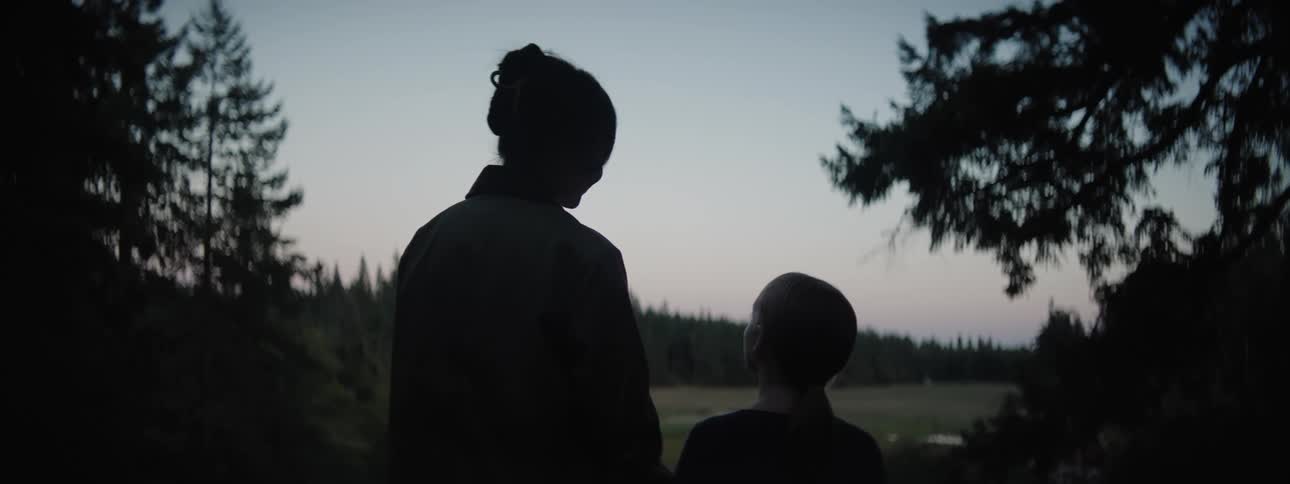 Mother and daughter admiring the forest landscape at dusk