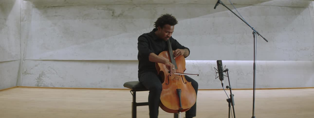 A man in a solo performance playing the cello