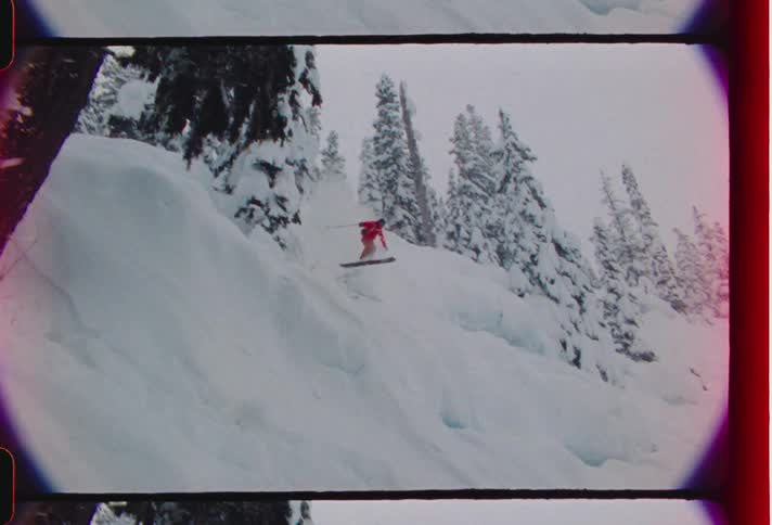 Person venturing into freefall on a mountain with snow on a snowboard