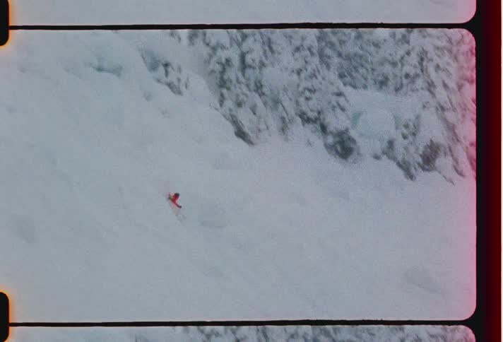 A person is skiing and does a trick and when he lands he falls on the ground which is covered with snow and there are some pine trees around