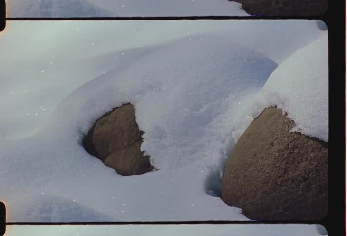 A close up of smooth rocks covered in snow