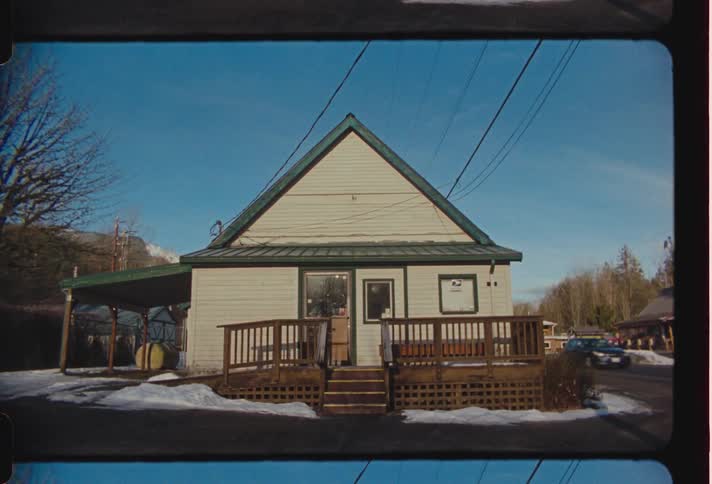 Car drives past houses in small town during winter