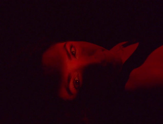 A woman sleeping in a room with a red light
