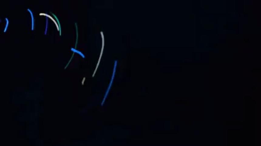 Spinning colorful lights against a black background