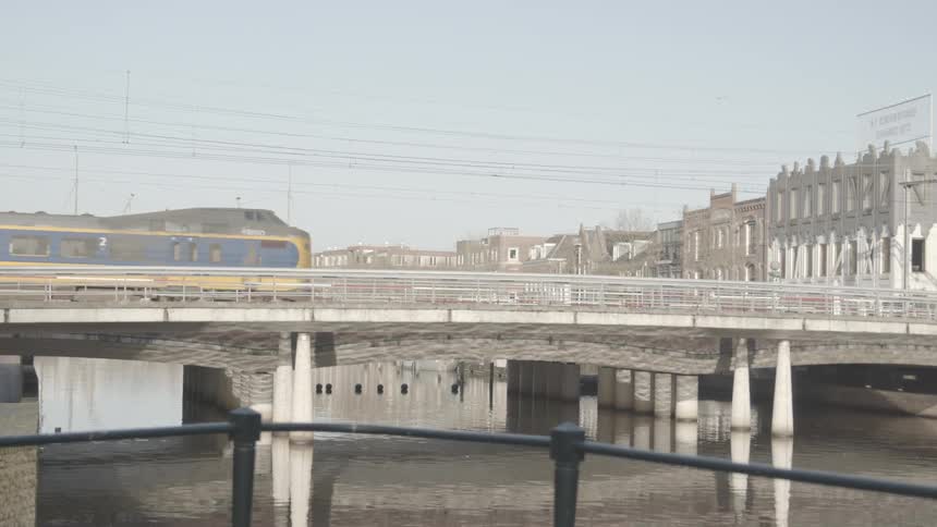 A train crosses a bridge over a river in the city