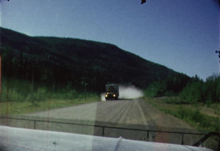 A big rig truck passes on a dirt road