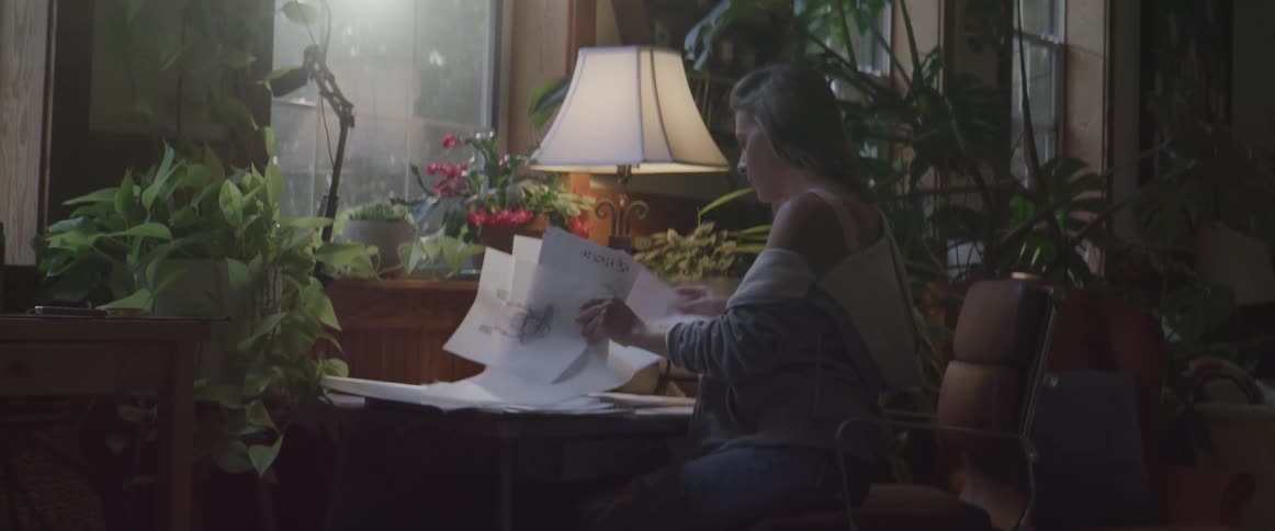 A white woman sits in a chair and shuffles through some papers