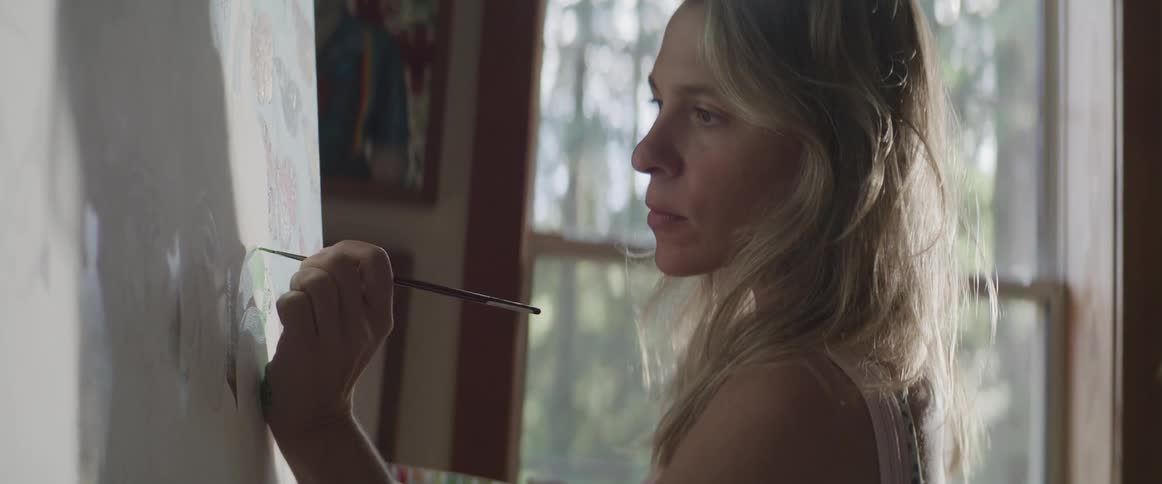 A clip of a female artist painting on a canvas