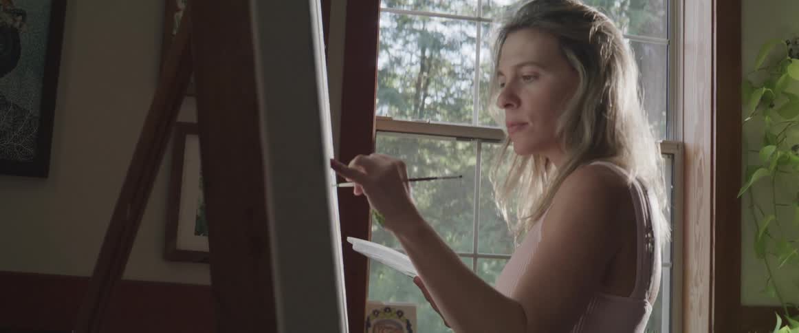 A clip of a female artist painting on a canvas