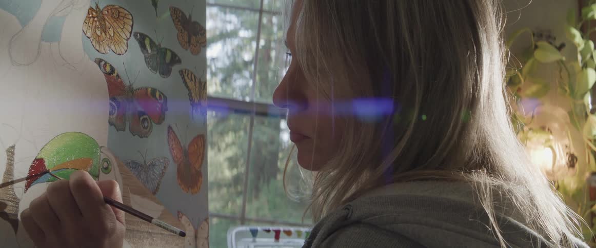 A woman painting on a canvas in a house