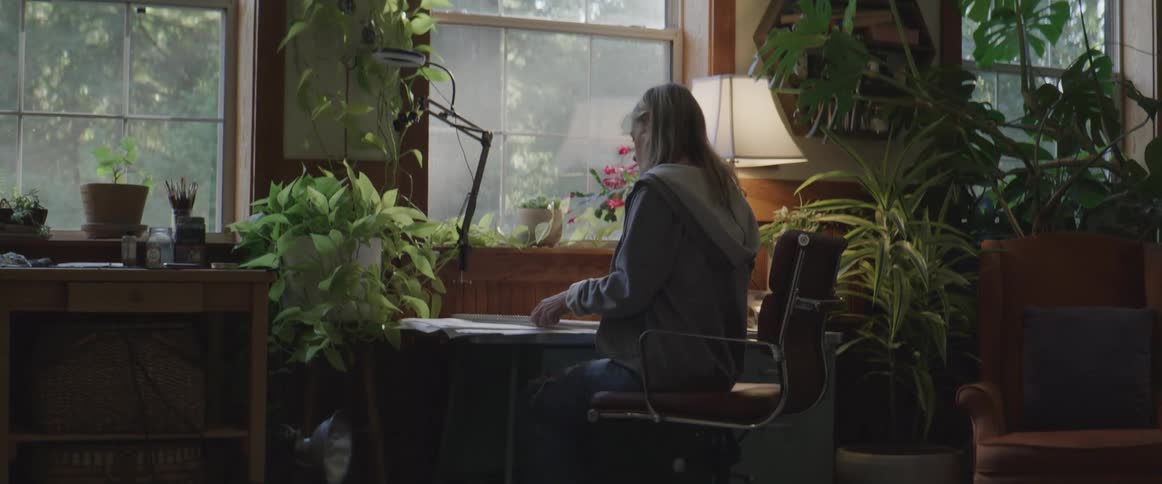 Blonde artists sits down with sketchpad and starts drawing