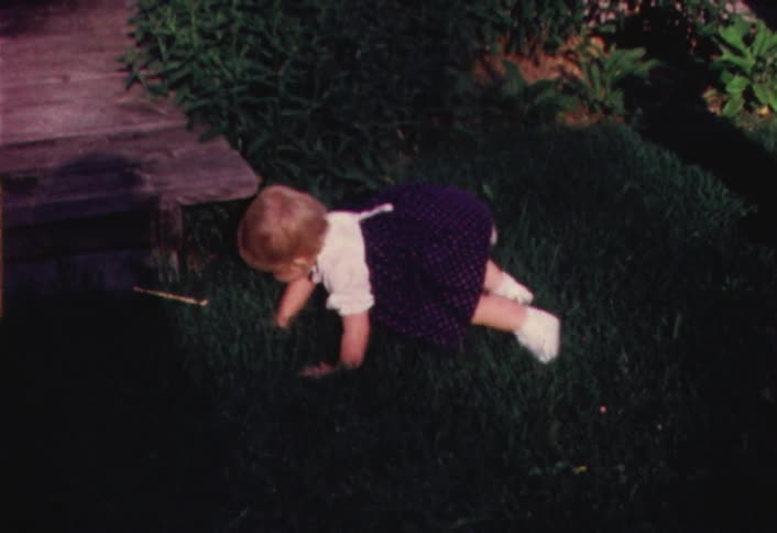 Toddler in a skirt crawling outdoors