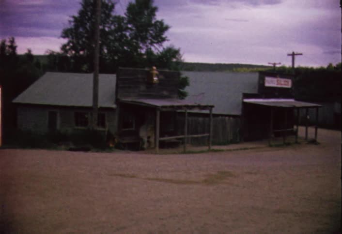 A shop sits in a large lot at sunset