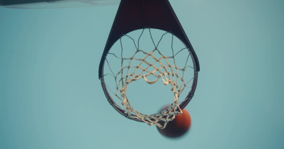 A basketball that is shot passes through the center of the basketball hoop