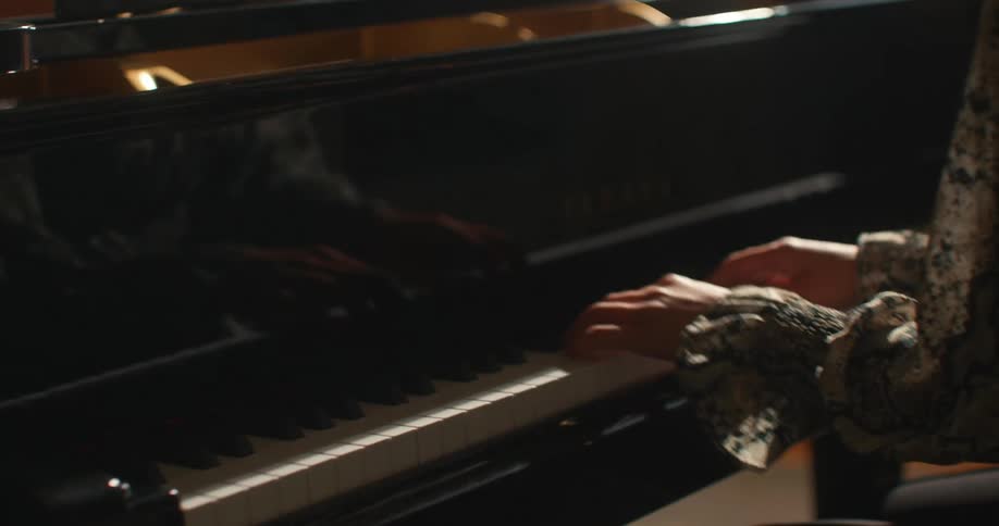 Closeup of a womans hands playing the piano