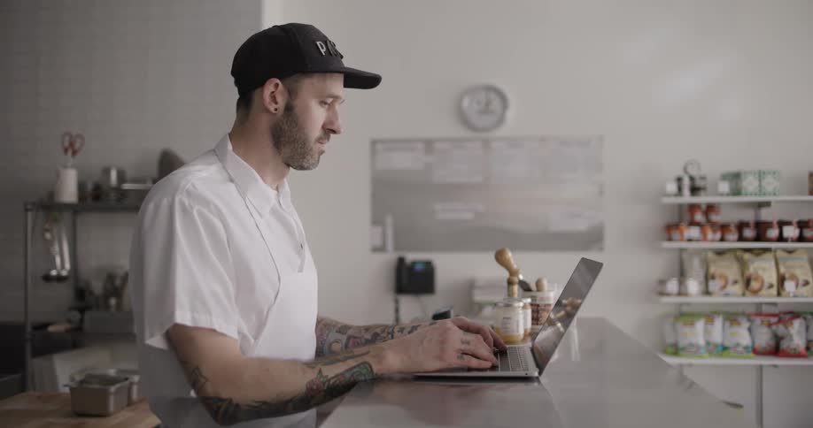 A man typing on a laptop at a store counter