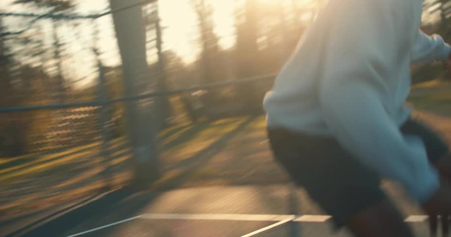A man playing basketball alone outdoors
