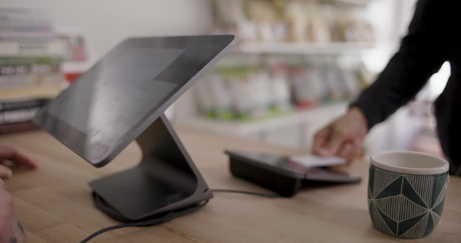 A person is making a payment at a counter with a card