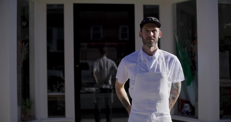 Portrait of a man smiling and wearing a white apron